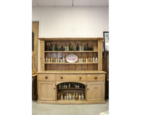 19th century Pine Dresser, the upper section with two shelves above three drawers and central pot shelf flanked to two Cupboa