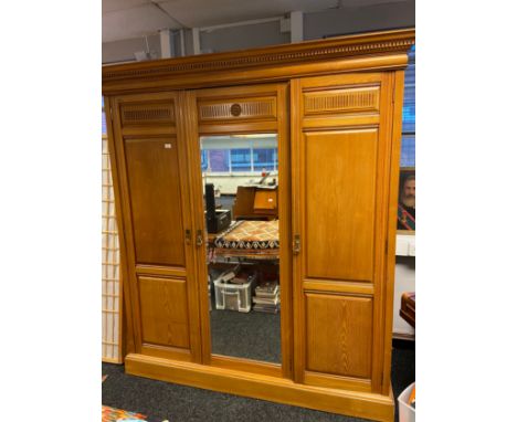 A Large Victorian triple wardrobe made from light oak, fitted with interior drawers and single full length mirror door. [214x