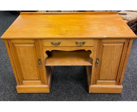 19th century light wood knee hole writing desk, centre drawer above an open shelf, flanked by two panelled doors leading to i