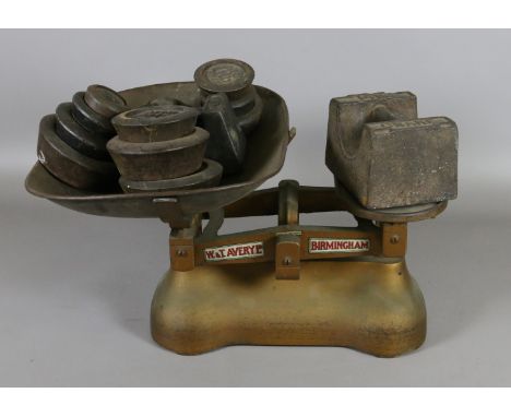 A set of cast iron W & T Avery scales and a large collection of cast iron weights.