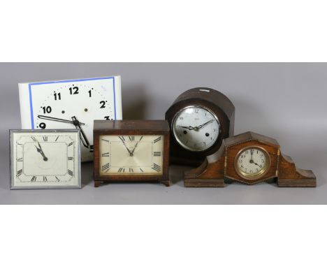 A 1950s ceramic wall clock, a chrome strut clock and three oak cased mantel clocks.