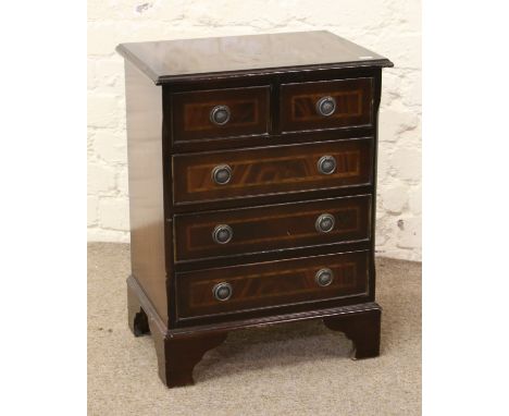 A mahogany bedside chest of drawers crossbanded and raised on bracket feet.