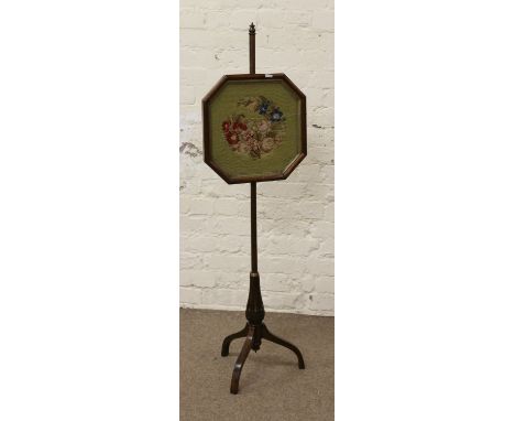 A Regency rosewood pole screen with woolwork floral panel and raised on a tripod base.