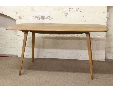 An Ercol Golden Dawn light oak dining table raised on tapering square cut splayed legs.