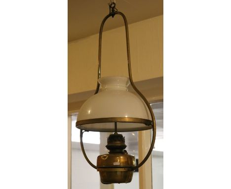 A Victorian brass hanging oil lamp and milk glass shade later converted to electricity.