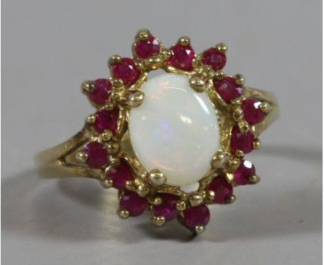 A ladies 9ct gold ring set with an opal and garnets, size M.