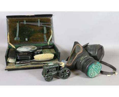 A leather fitted travelling vanity case, a tilly lamp, cased gas mask, cast and painted toy tractor and a part fireside compa