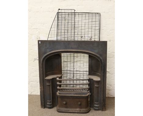 A Victorian cast iron fire insert ornamented with fluted column supports and a wire fireguard.