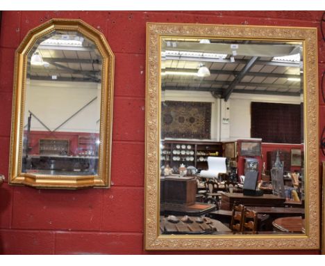 A gilt framed wall mirror, shaped arch top with mirrored shelf to base, 85cm high; another, large rectangular mirror, the gil