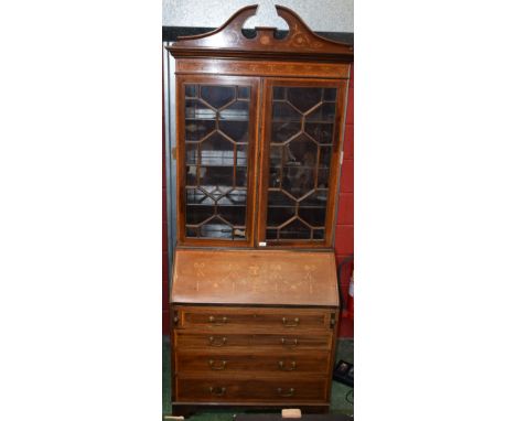 A Sheraton Revival mahogany and marquetry bureau bookcase, broken arch pediment above a frieze inlaid with ribbon-tied traili