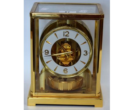 A Jaeger Lecoutre brass Atmos clock, 10.5cm dial with baton markers and Arabic numerals to quarters, skeleton movement with l