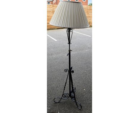 A late 19th/early 20th century wrought metal telescopic standard lamp, scroll triform base