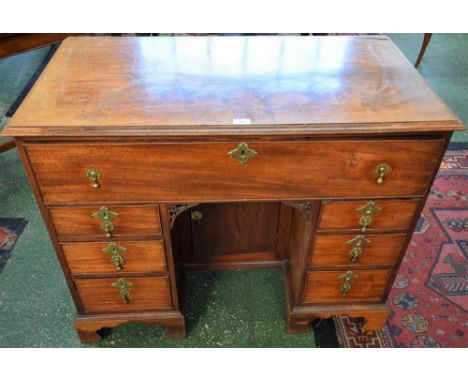 A George III mahogany kneehole desk, rectangular moulded top above a deep cockbeaded frieze drawer, cupboard to niche flanked