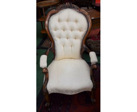 A Victorian walnut armchair, shaped spoon back, scroll arms, carved throughout with scrolling acanthus, stuffed over upholste