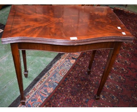 A 20th century mahogany serpentine card table, folding top enclosing a baize lined playing surface, tapered square legs, spad