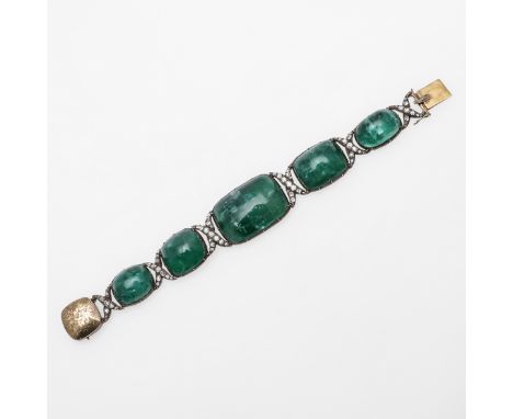 formed with five graduated oval-shaped foil backed cabochon emeralds, each divided by a cross-over section mounted with cushi