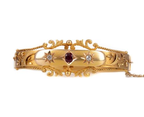 VICTORIAN RUBY AND DIAMOND BANGLE,the central ruby flanked by two old cut diamonds, with overlaid decoration to the panel, wi