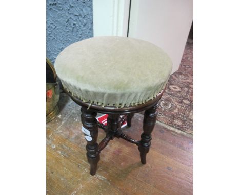 AN EDWARDIAN MAHOGANY REVOLVING STOOL the circular upholstered seat raised on turned legs joined by cross stretchers