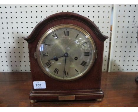 A MAHOGANY CASED MANTLE CLOCK the rectangular arched dial with silver dial and Roman numerals raised on brass bun feet 28cm h