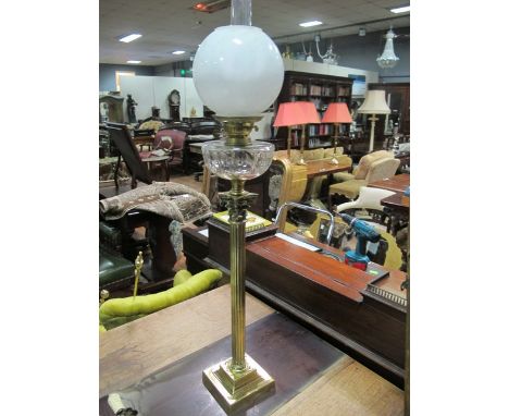 A VICTORIAN BRASS OIL LAMP the faceted resevoir above a reeded column with corinthian capital raised on square stepped base 1