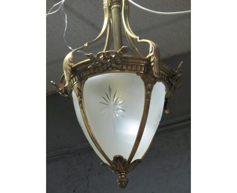 A CONTINENTAL GILT BRASS AND FROSTED GLASS CENTRE LIGHT the circlet hung with stylized foliage decoration with star cut panel