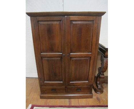 AN OAK CABINET of rectangular outline the shaped moulded top above panel doors the interior with adjustable shelf two short a