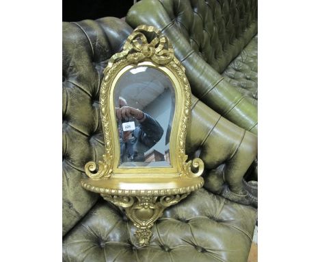 A CONTINENTAL GILT FRAME MIRROR the shaped bevelled glass plate within an egg and dart moulded frame ribbon tied cresting abo