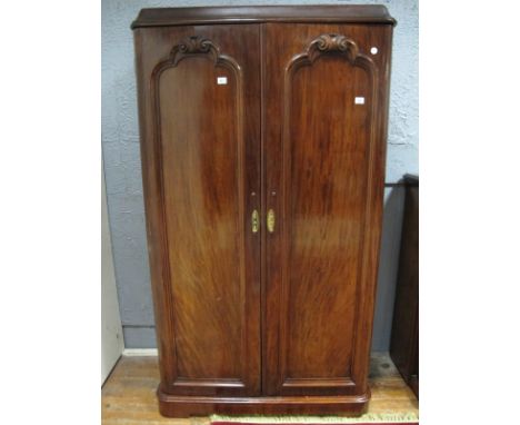 A GOOD VICTORIAN MAHOGANY TWO DOOR WARDROBE the moulded cornice above a pair of rectangular arched panelled doors with scroll