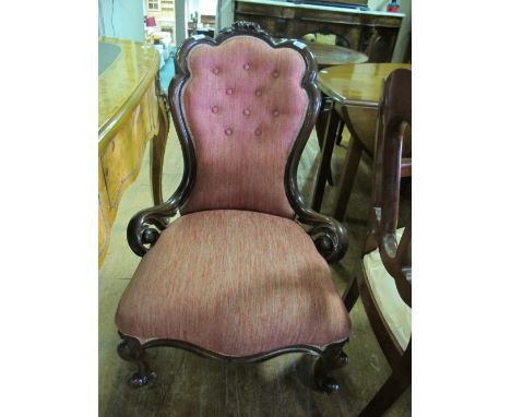 A VICTORIAN WALNUT LADIES CHAIR the foliate and flowerhead carved cresting above a button upholstered back and seat on cabrio