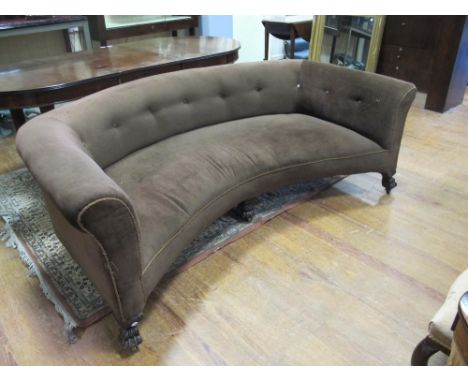 A VICTORIAN MAHOGANY AND UPHOLSTERED SETTEE of crescent outline the shaped top with deep button upholstered back and arms rai