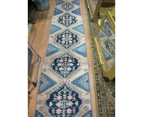A WOOL RUG the light pink and indigo ground with central diamond panels