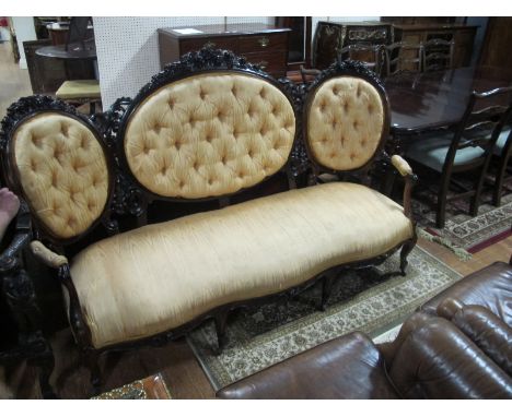 A GOOD VICTORIAN MAHOGANY TRIPLE CHAIR BACK SETTEE the foliate and flowerhead cresting above deep button upholstered panel an