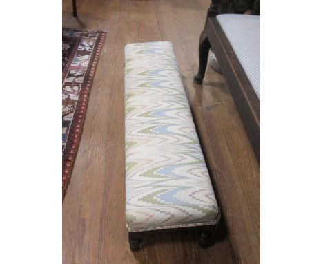 AN EDWARDIAN MAHOGANY UPHOLSTERED STOOL the rectangular upholstered seat above a reeded apron on turned legs 135cm (w) x 30cm