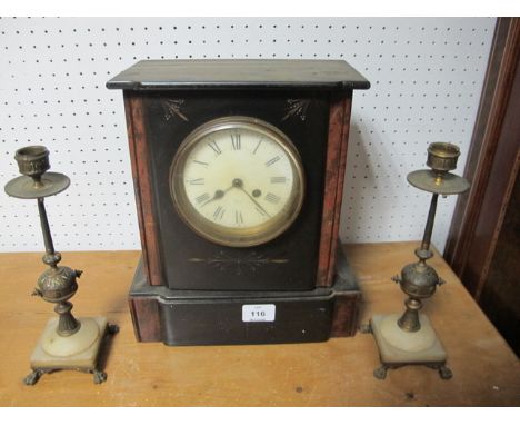 A BLACK SLATE MANTLE CLOCK together with a pair of brass candlesticks