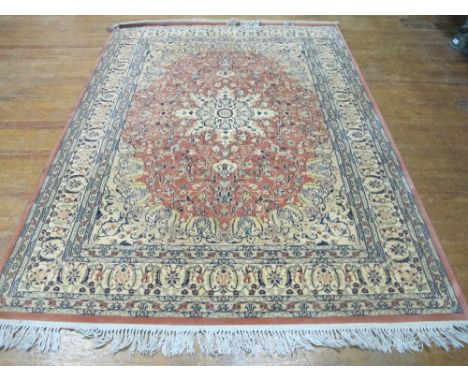 A WOOL RUG the beige and light pink ground with overall floral decoration 236cm x 177cm