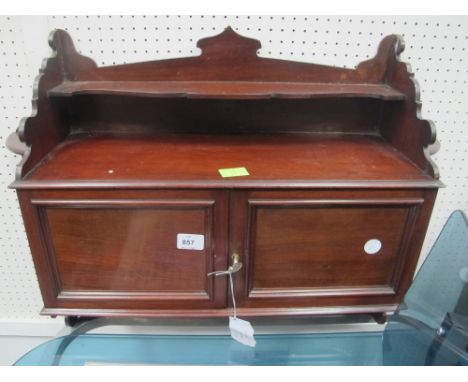 AN EDWARDIAN MAHOGANY WALL MOUNTED CABINET of rectangular form the super structure with moulded shelf above an open compartme