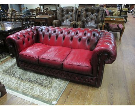 A WINE HIDE UPHOLSTERED LIBRARY COUCH with deep button upholstered back and seat with loose cushions 183cm wide