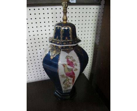 A CHINA TABLE LAMP of octagonal form the blue and white ground decorated with panels of exotic birds raised on a ebonised bas