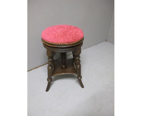 AN EDWARDIAN MAHOGANY STOOL the circular upholstered seat raised on turned legs joined by an under tier 53cm high