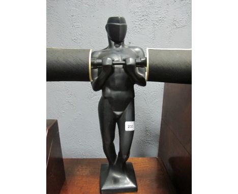 A FIGURAL TABLE LAMP modelled as a Gentleman shown standing holding a bar issuing two candle lamps 56cm high