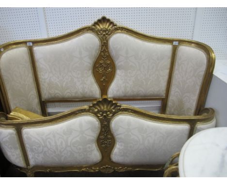 A CONTINENTAL GILTWOOD AND UPHOLSTERED BED the arched headboard with shell cresting and upholstered panels with conforming fo