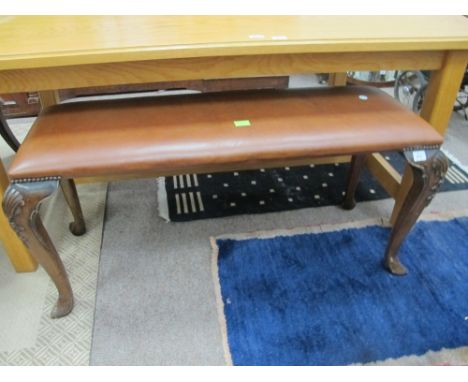 A MAHOGANY AND UPHOLSTERED STOOL the rectangular upholstered seat raised on cabriole legs with carved knees 55cm (h) x 115cm 