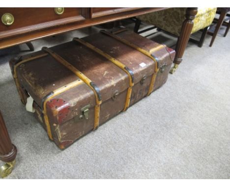 A CANVAS UPHOLSTERED CABIN TRUNK with beechwood and metal straps and brass locks