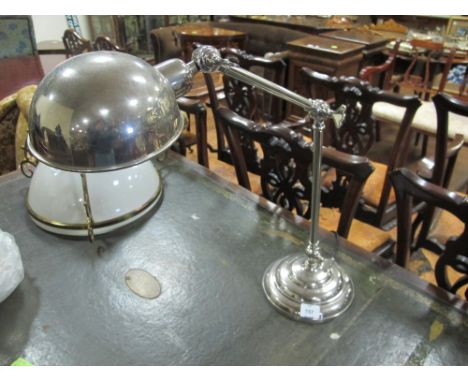 A CHROME ANGLE POISE READING LAMP raised on a circular spreading foot
