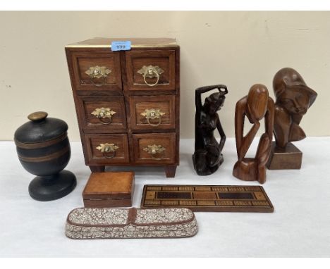 A brass mounted miniature chest of drawers; a decorated pen box; a treen box; three carved wood sculptures; a treen goblet wi