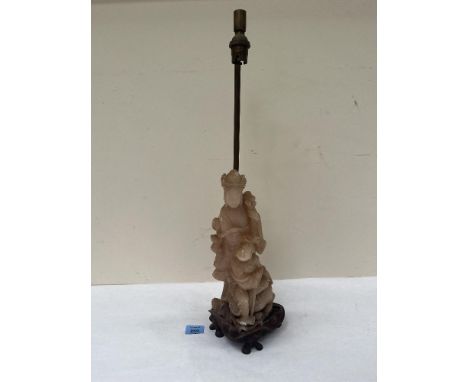 A 1920s soapstone lamp base carved as a figure of Guanyin. The figure and wood base 13½' high. Losses