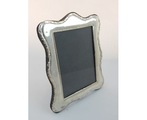 Silver mounted photograph frame, the serpentine shaped frame with a rectangular aperture and easel back, 19cm h