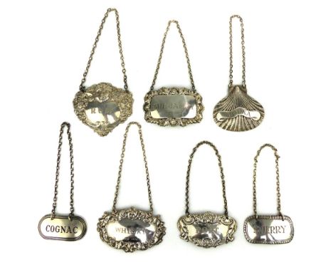 Silver clam shell Vodka decanter label, four Victorian style embossed silver decanter labels and two other silver labels. (7)