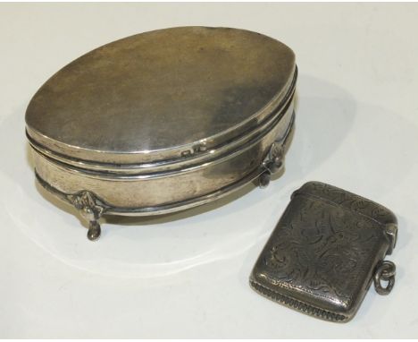 A silver trinket box of elliptical shape raised on four pad feet, 8cm long, Birmingham 1905 and a small silver Vesta case, Bi