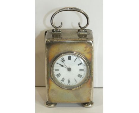 A silver cased miniature carriage clock with French movement and plain silver case with C scroll handle and four bun feet, Bi